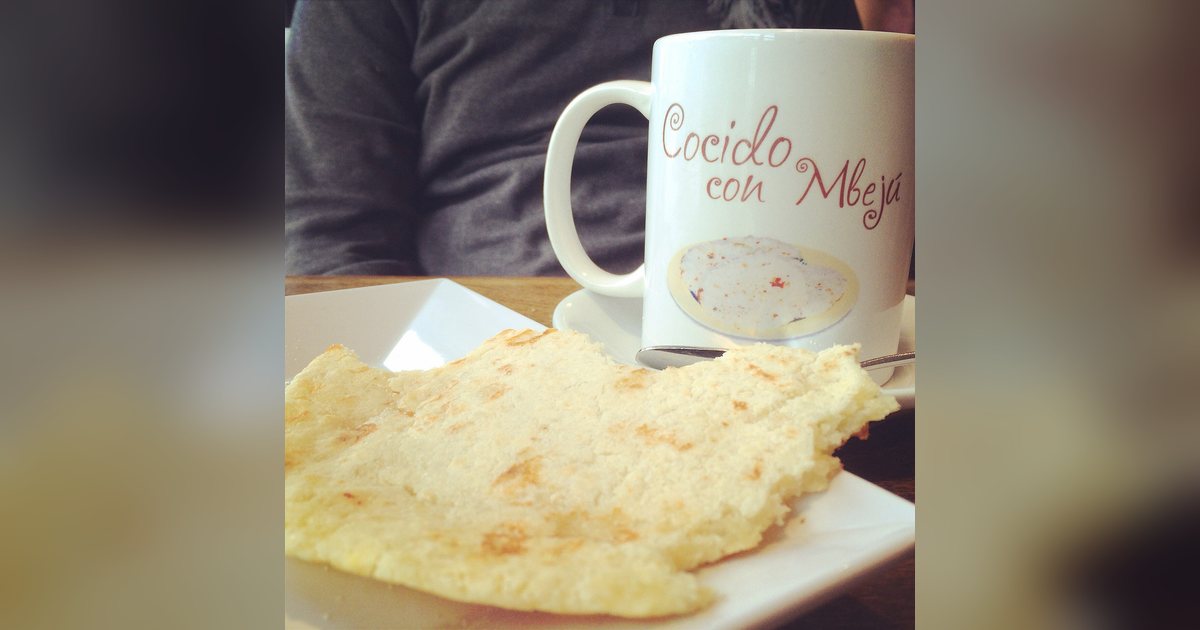 Mbeju servido con una taza de cocido en la mesa de un café