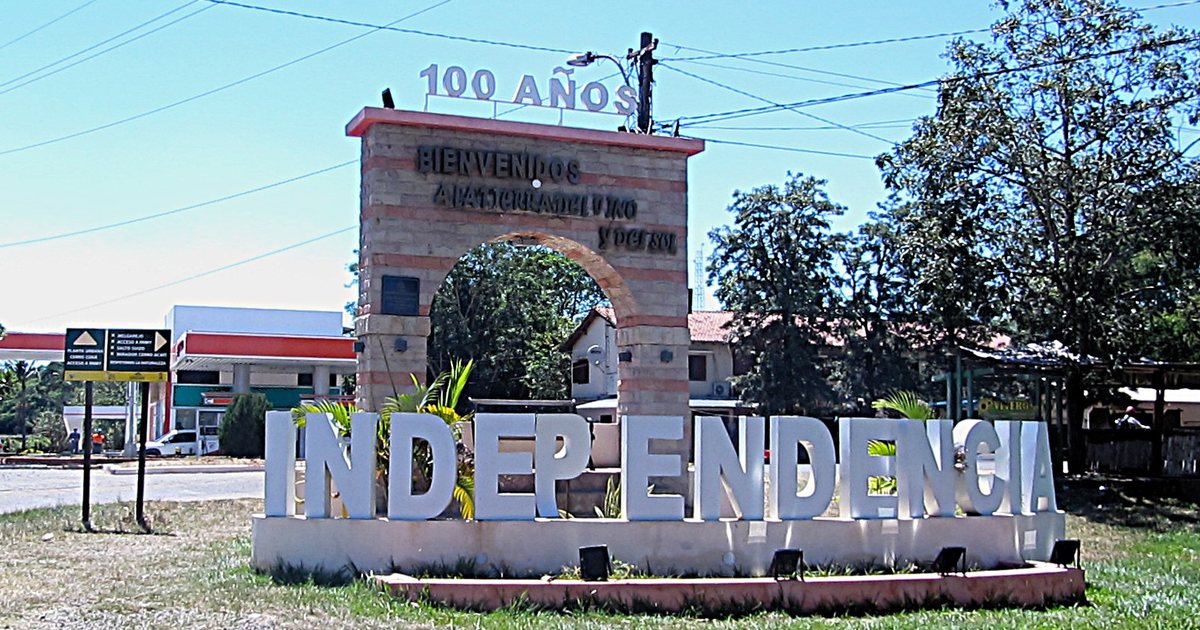 Arco de bienvenida y letras con el nombre de la ciudad en el acceso a Colonia Independencia, Guairá