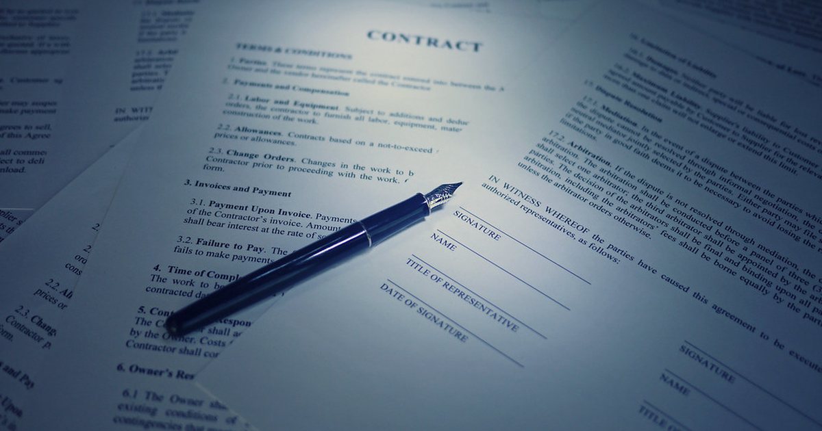Contrato y firma sobre una mesa