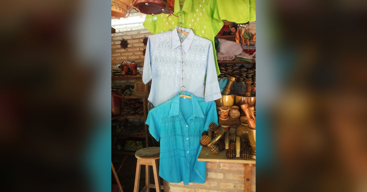 Camisas de ao po'i bordadas a mano, colgadas en un puesto de artesanía de Atyrá, en Cordillera