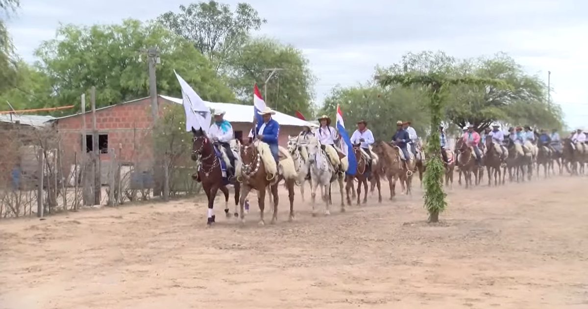 Jinetes con banderas paraguayas desfilan en una jineteada en Teniente Esteban Martínez, departamento de Presidente Hayes