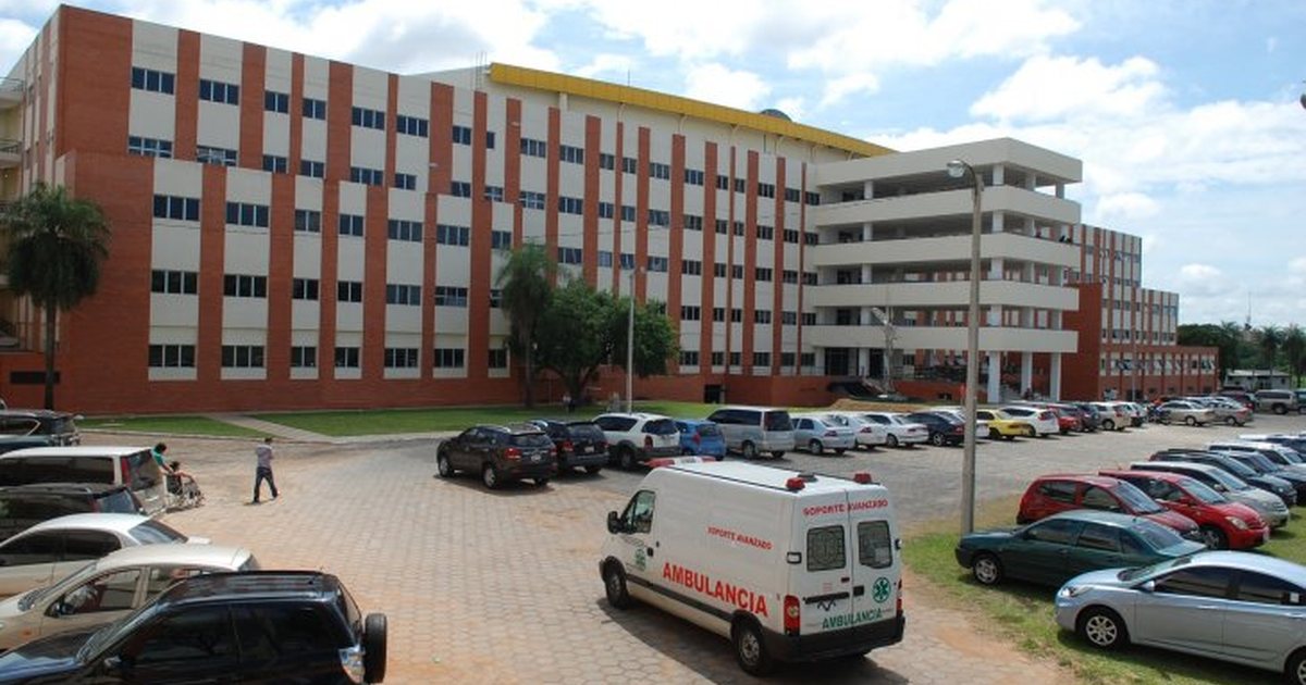 Fachada del Hospital de Clínicas en San Lorenzo, con una ambulancia en el estacionamiento