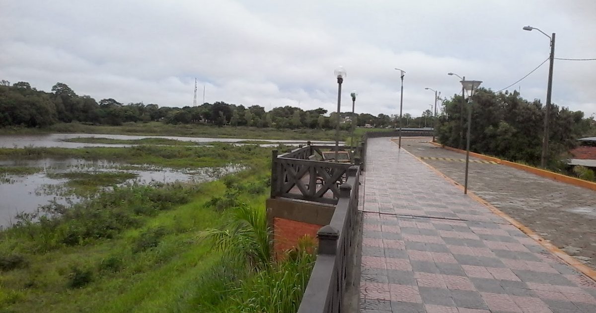 La costanera de Pilar junto al arroyo Ñeembucú, con el paseo peatonal, las farolas y el agua crecida al costado