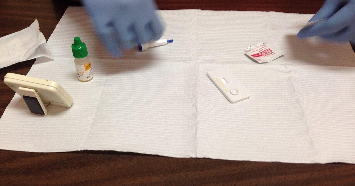 Prueba rápida de VIH lista sobre una mesa, con guantes y materiales de toma de muestra