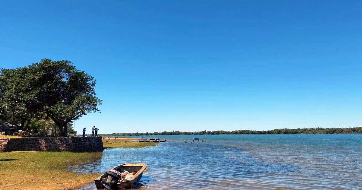 El río Paraná a orillas de Ayolas, Misiones, con una lancha amarrada en la costa