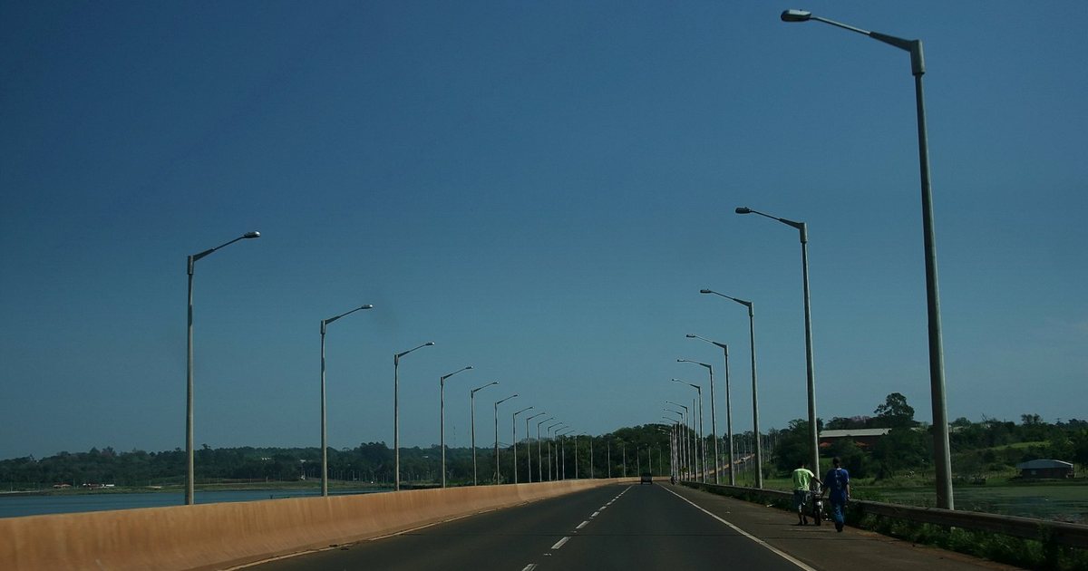 La ruta PY01 en el acceso a Encarnación, con columnas de alumbrado a los dos lados de la calzada