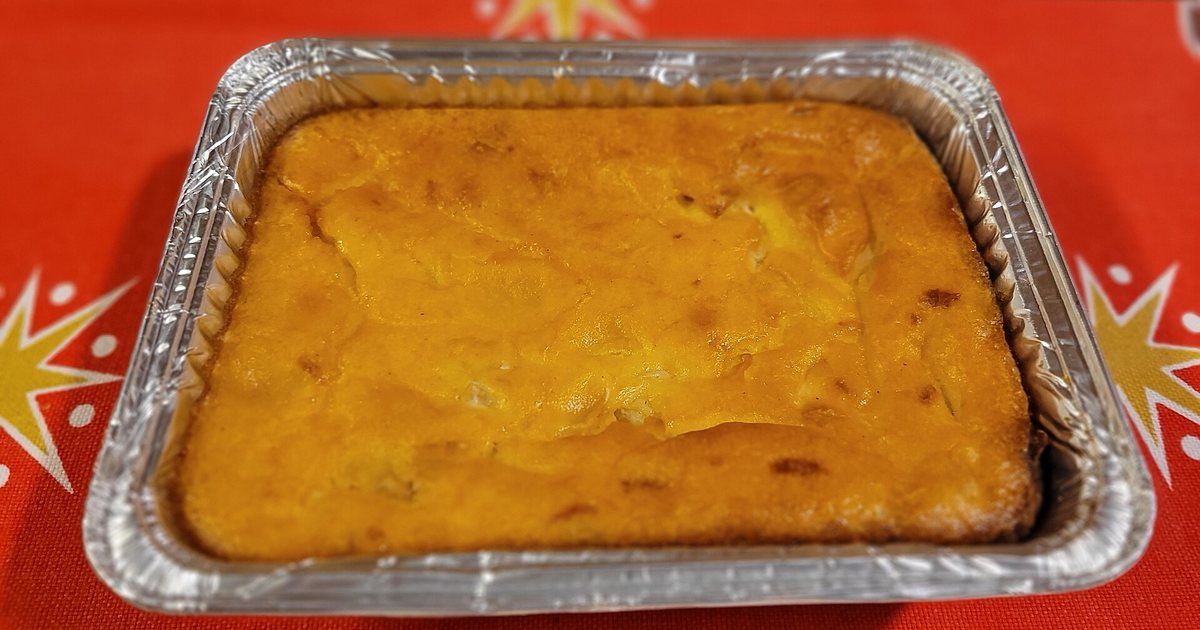Una sopa paraguaya recién horneada en bandeja, sobre un mantel navideño