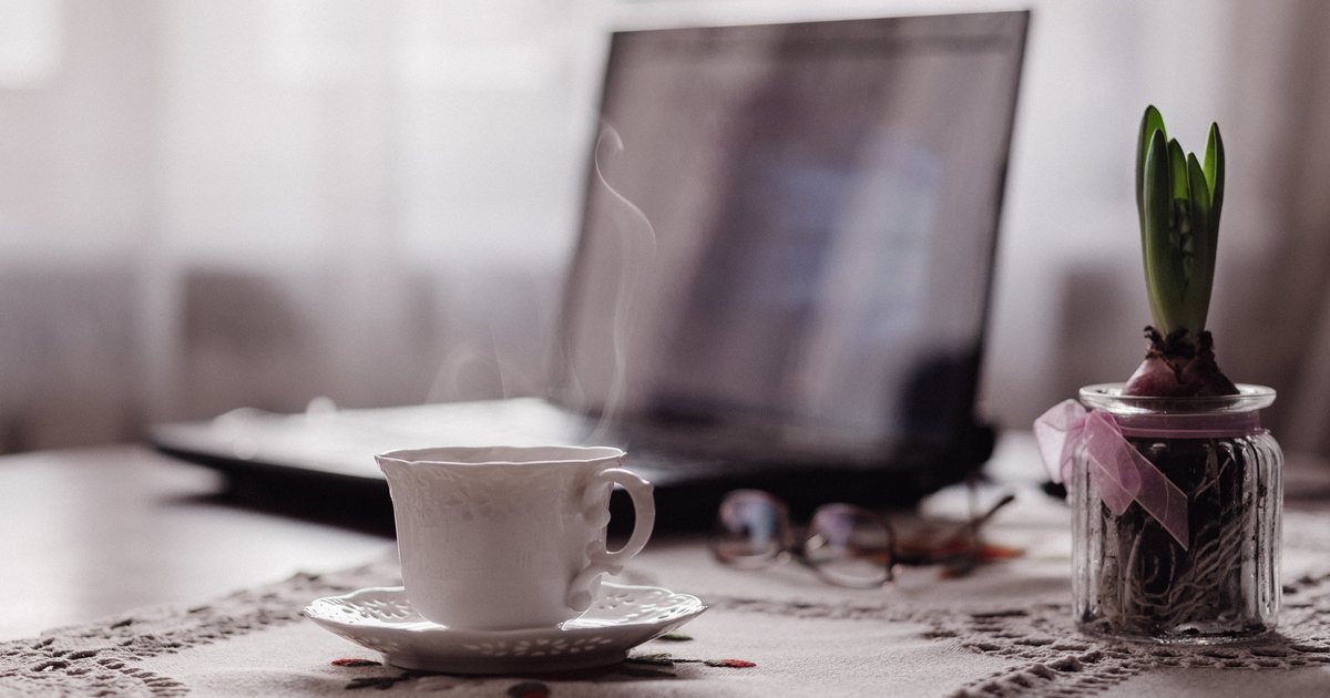 Taza de café y computadora portátil sobre una mesa